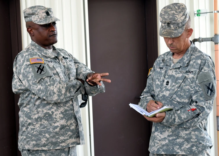 two men in military fatigues standing next to each other