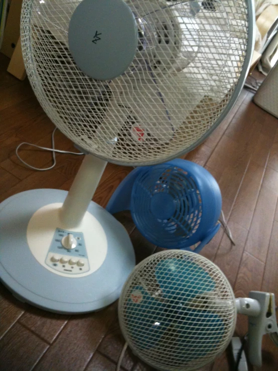a white electric powered heater and a blue fan