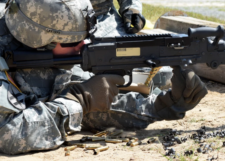 a soldier with a gun sits in the ground