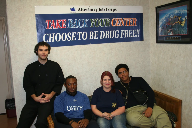 four people are posing on the couch for a po