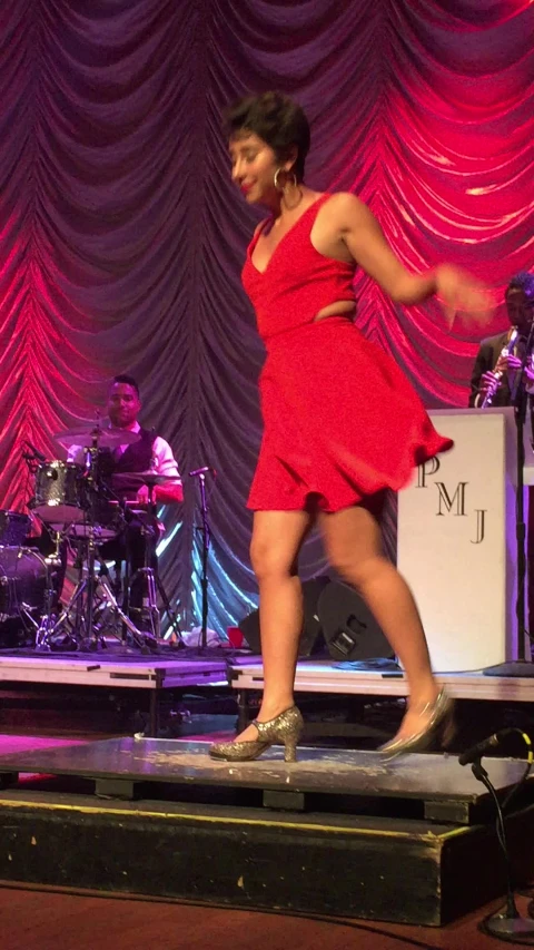 a person wearing red clothing walking on a stage