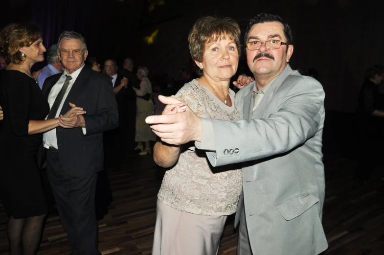 a man and woman dancing together in a dance hall