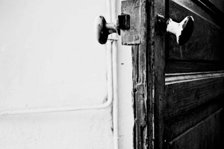 an old wooden door has a white door handle