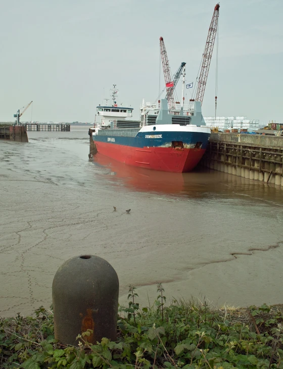 a boat docked in the port area while a crane is up on it's roof