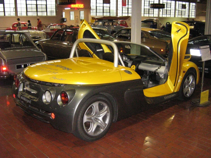 a small yellow car is on display in a parking lot