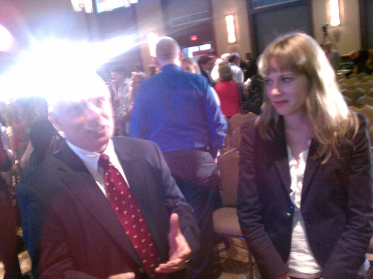 an older couple standing side by side in a conference room