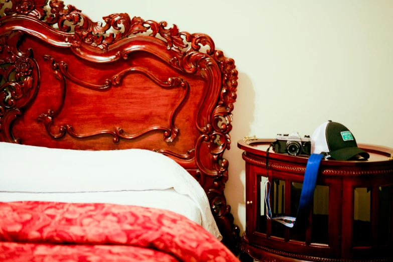 bed and nightstand with red covers and pillows