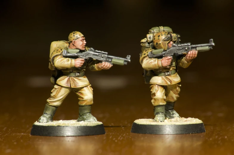 two toy soldiers that are on a table
