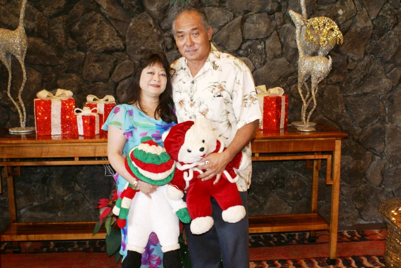 a man and woman pose with their teddy bears