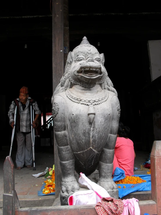 a large stone sculpture standing on steps next to a woman