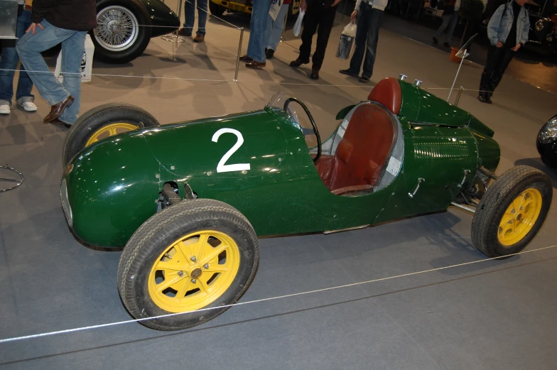 a green race car is on display in a show room