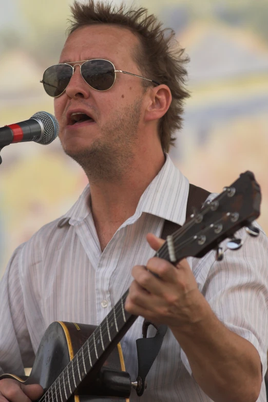 a person with sunglasses on playing guitar