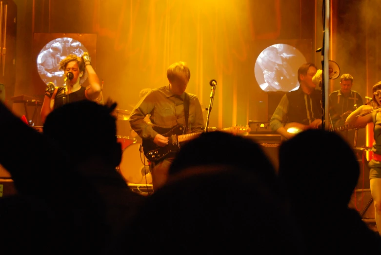 a band on stage performing and some fans watching