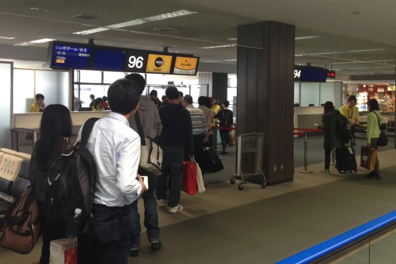 a group of people waiting to get on their luggage at an airport