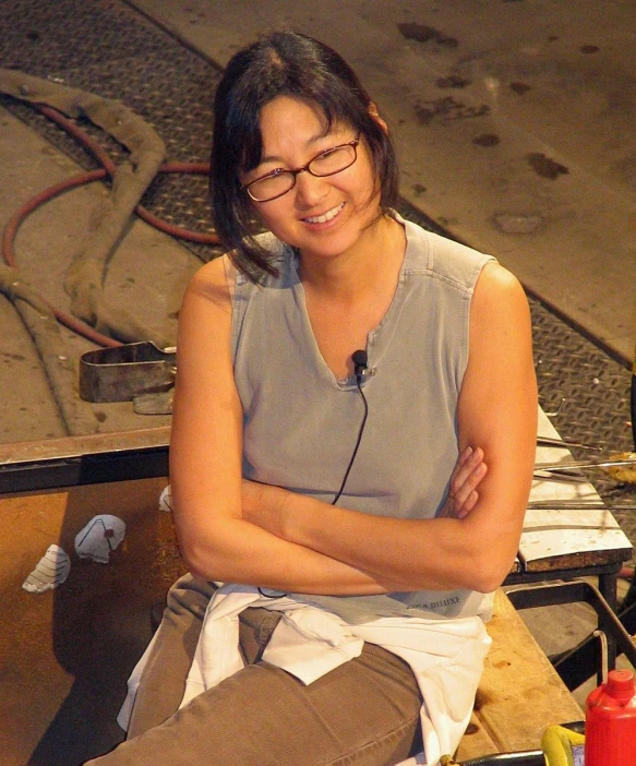 a woman sits on the ground with her arms crossed