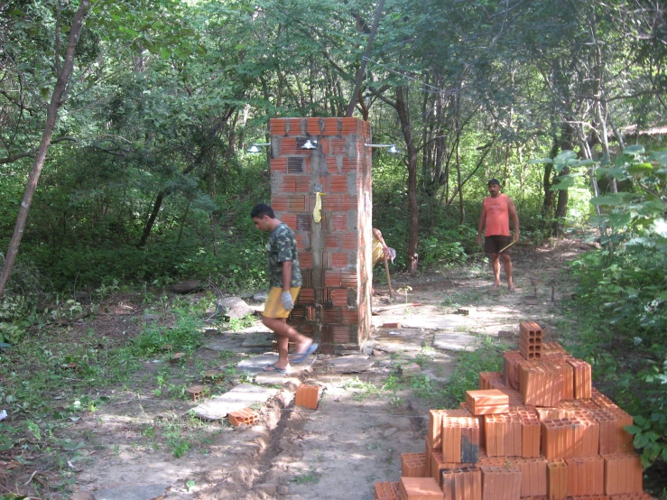 some guys that are standing by a very tall brick