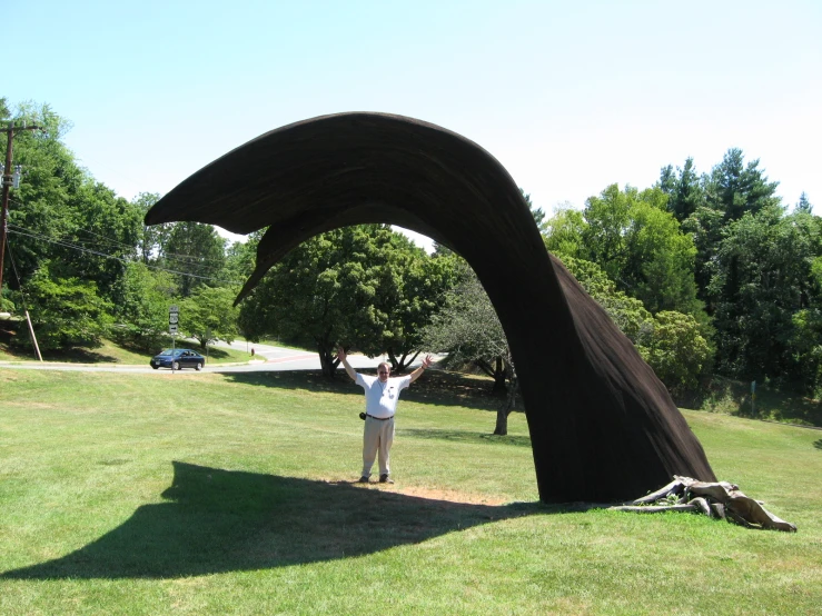 a man standing in front of a large sculpture