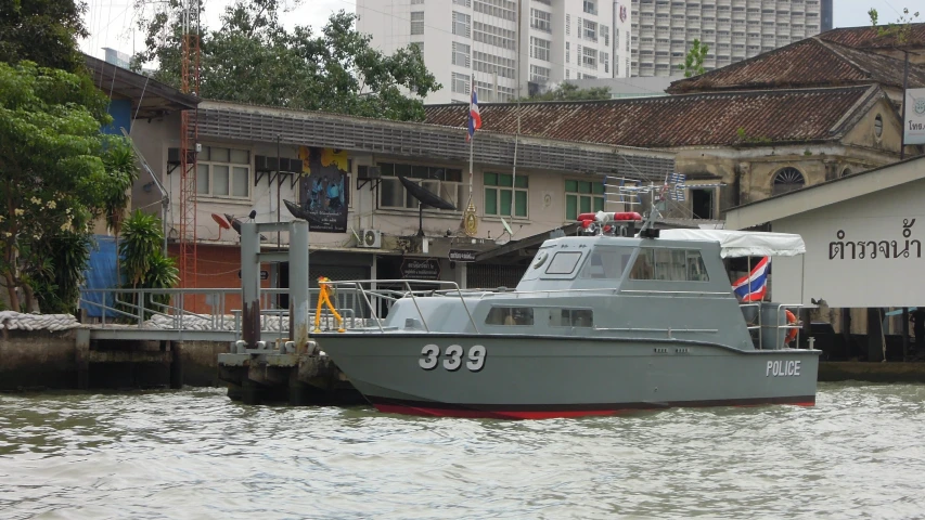 the boat is going through the water in front of the buildings