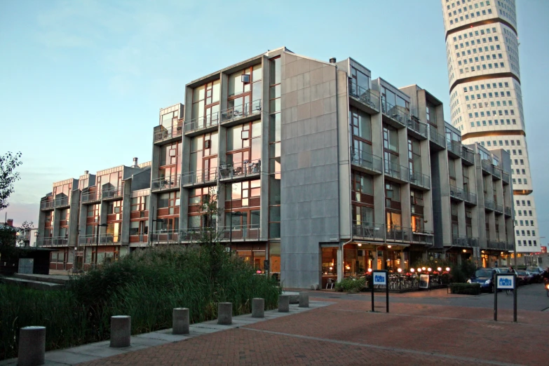 an apartment building sits next to a building at dusk