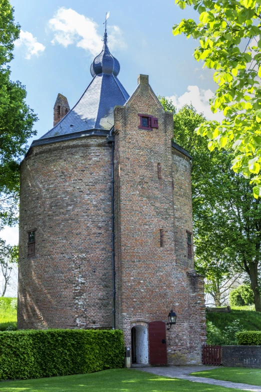 the tower of a brick building with a metal roof is made of stone and has a turret