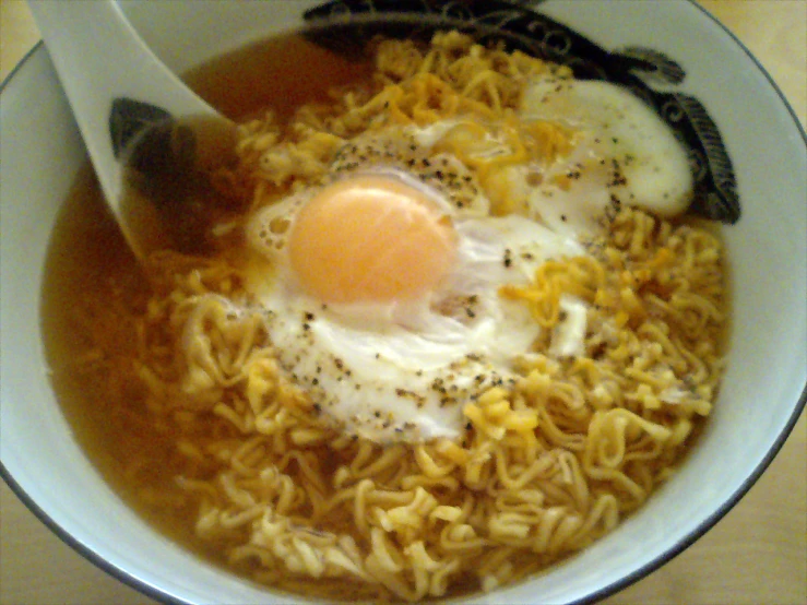 a bowl of noodles and two eggs in a sauce