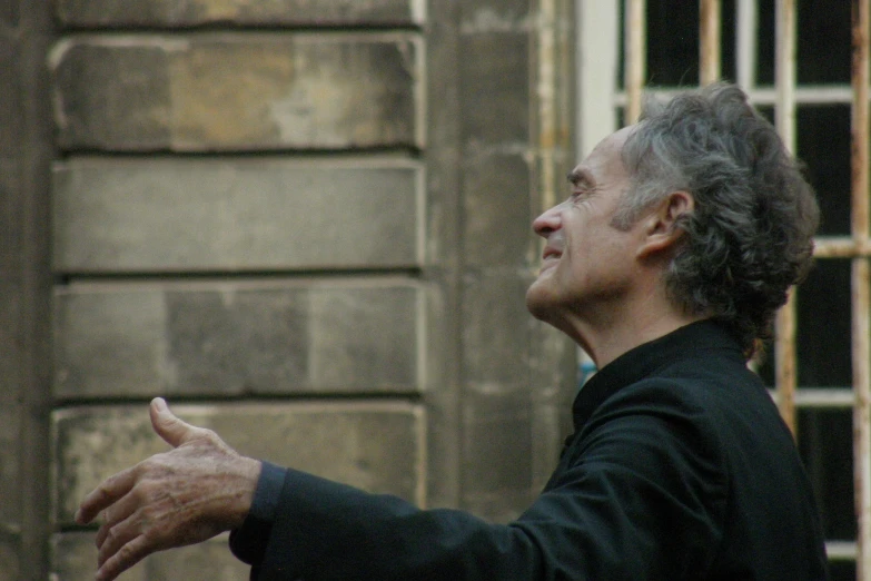 an older man standing in front of a barred window