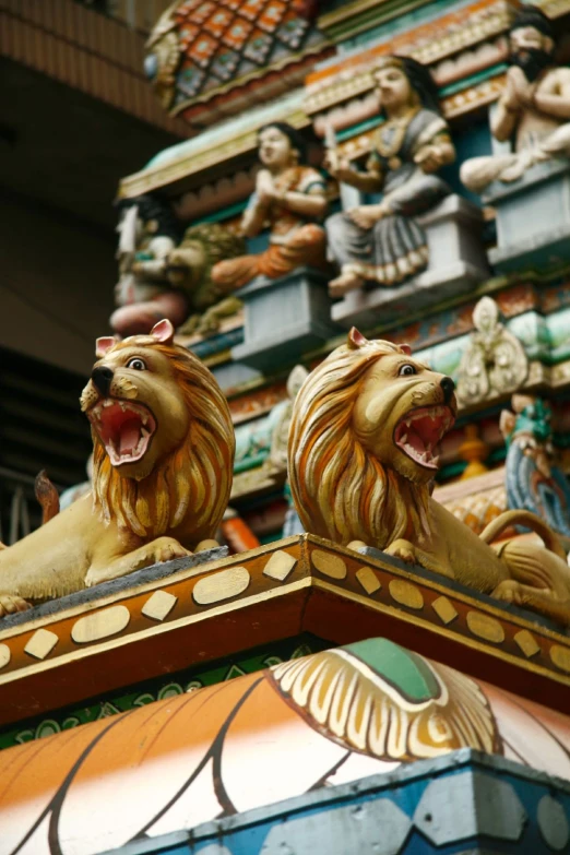 two golden lions sitting on top of an ornately decorated building