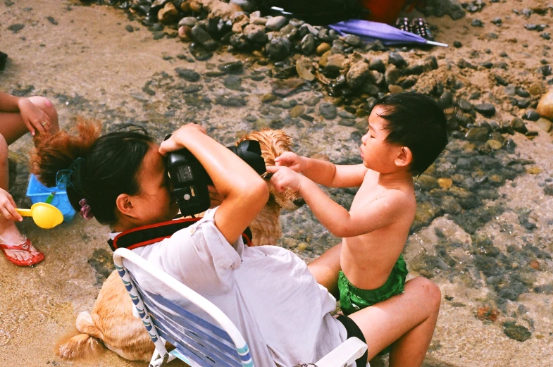 a man taking a child on the beach with a seashell