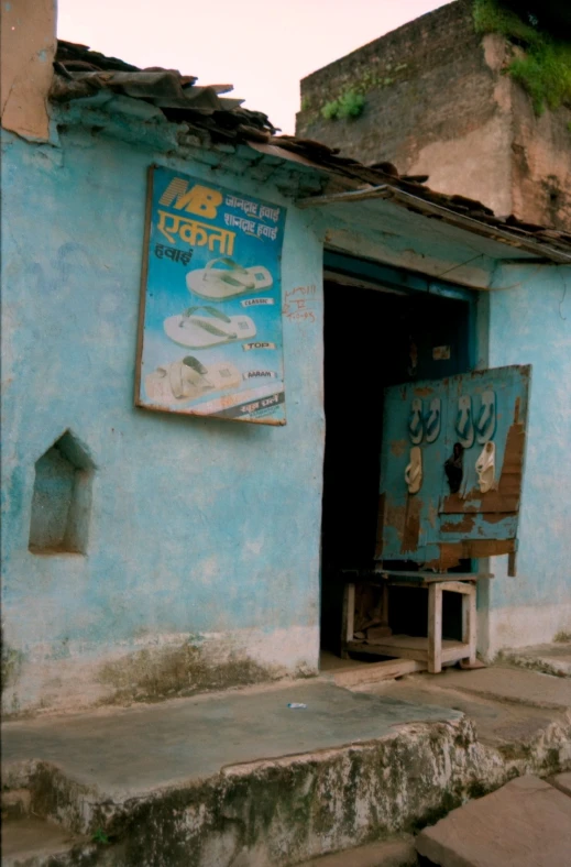 a doorway in a blue building with a sign above it