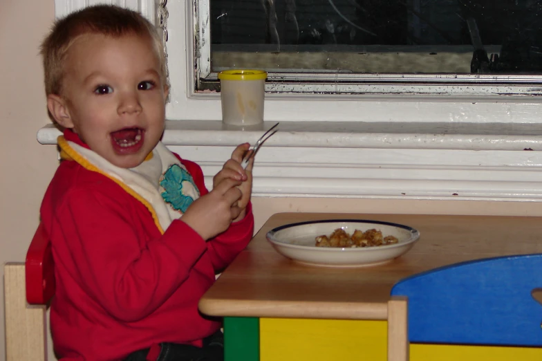 a child that is eating a cereal in a bowl