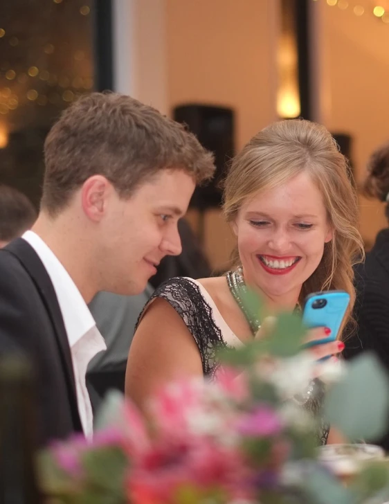 two people looking at a cellphone at an event