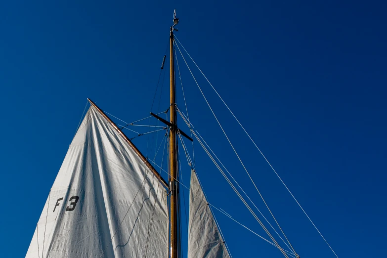 a sailing boat with a white sail and a blue sky