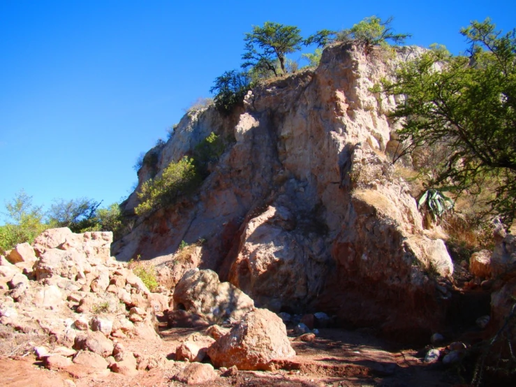 a mountain with rocks on it and trees on the side