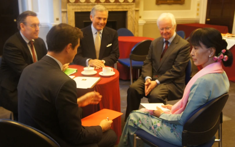 several people sitting around tables with red table cloths