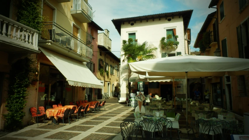 patio tables and chairs are sitting outside of the buildings