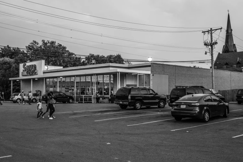 several people walk in front of an old gas station