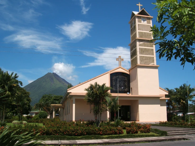 a small church with a steeple and trees near it