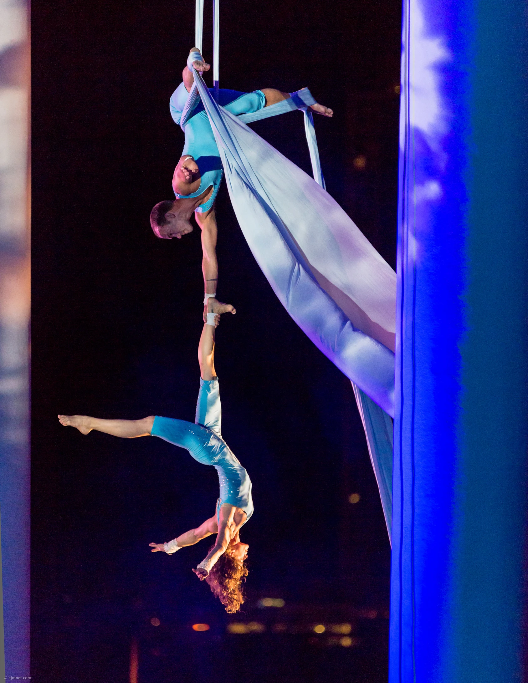 two aerial performers are doing acrobatic tricks