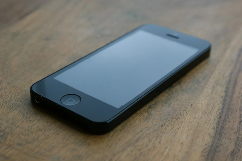 a cell phone is sitting on top of a wooden surface