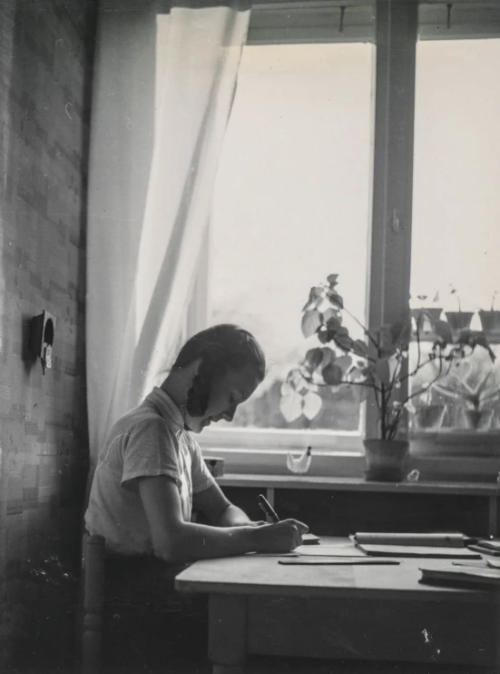 a man writing in an open desk area