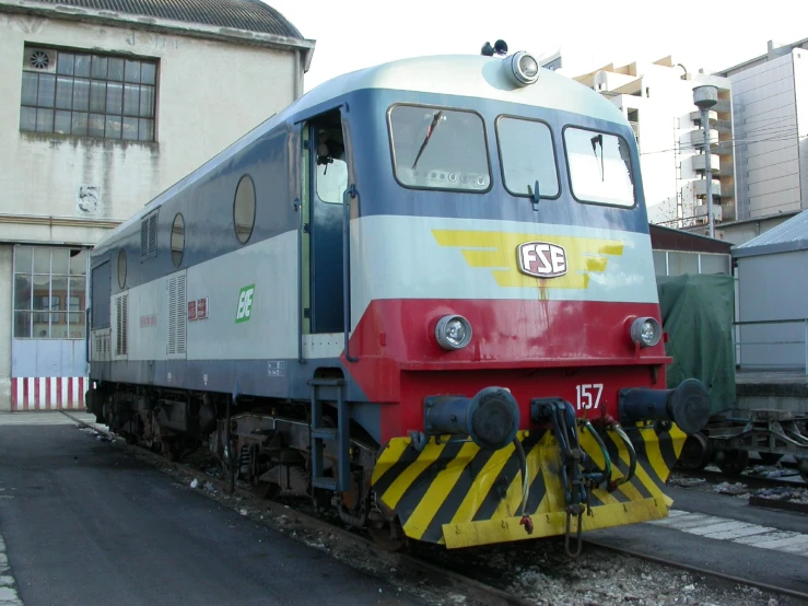 an older red and gray train on the tracks