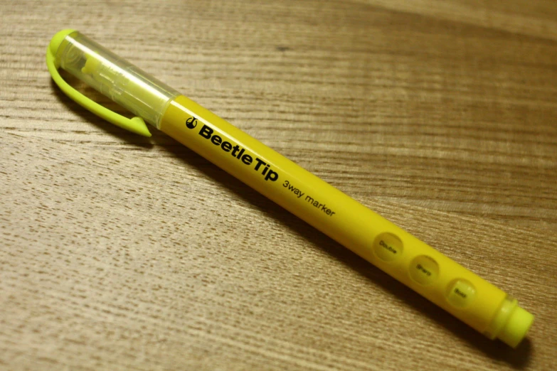 a yellow pens with some words on it sitting on the table