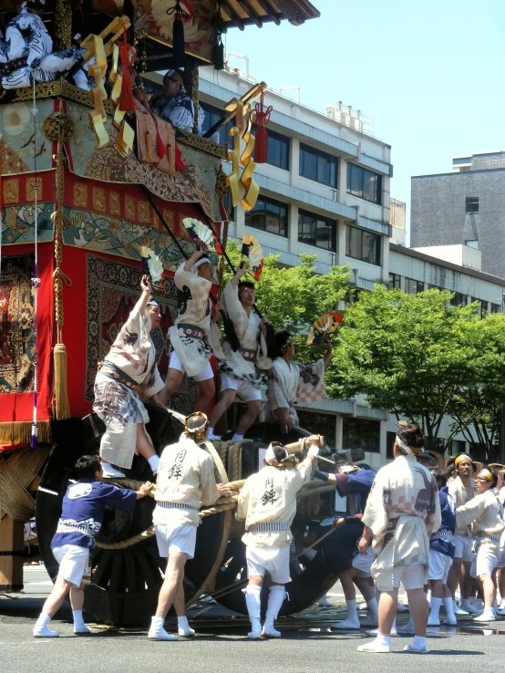 an old - fashioned parade float has men in white and are pulling another man on it