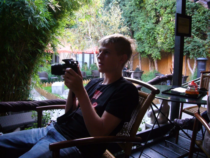 a man sits in a chair while taking pictures