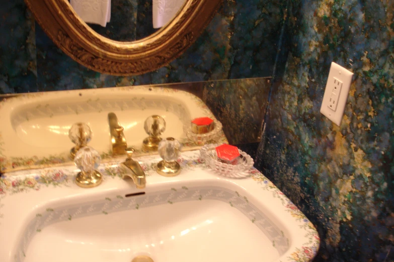 the sink in this bathroom has a mirror and blue floral wallpaper