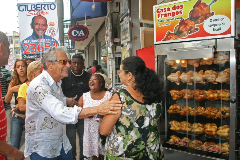 a man and woman are shaking hands next to a rack with pastries