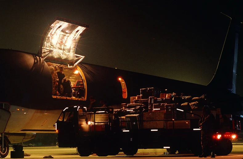 a large airplane sits on the runway with some trucks