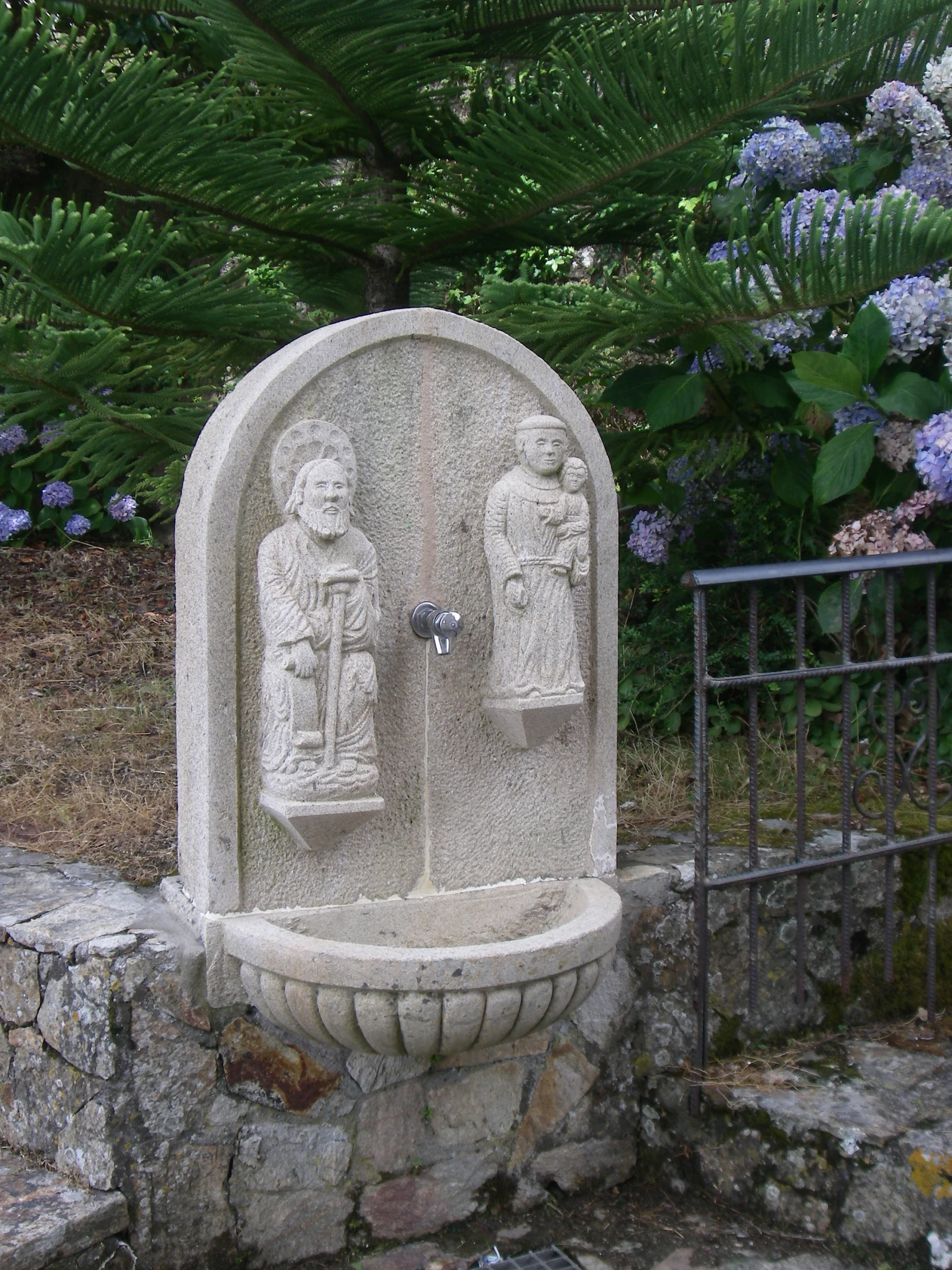 two statues made from stone near a gate