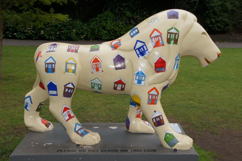 a white cow statue with many different colored stickers on it's body