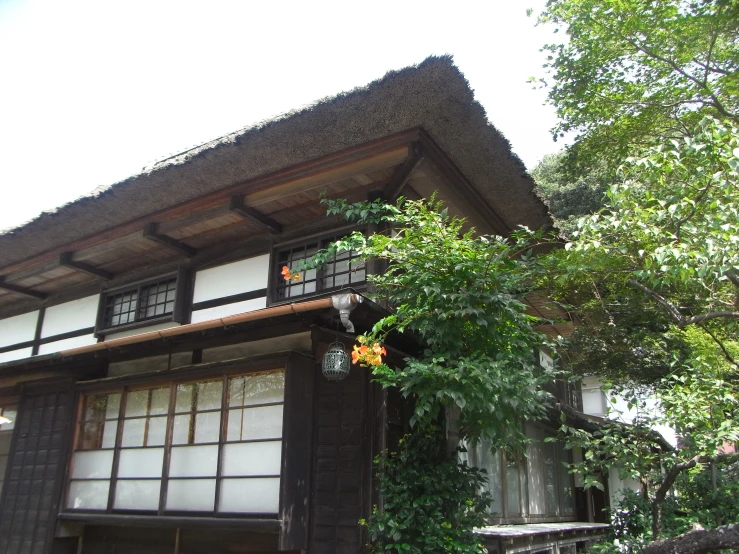 an ornate building with two stories with a small tree on the outside